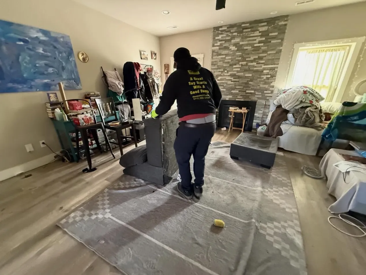 Eviction cleanout service in Champaign IL - The Mule Junk Removal team removing abandoned furniture, trash bags, and junk from rental property with truck